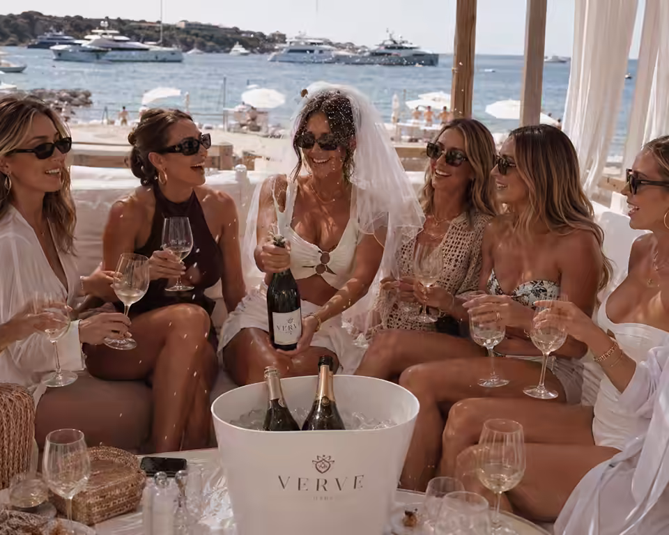 Bridal group celebrating with champagne at a Marbella beach club